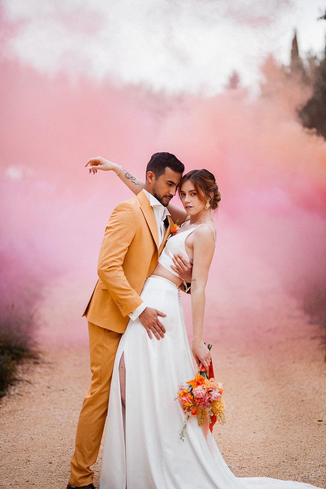 Couple de mariés et fumigènes roses pendant une séance couple au Château de Sienne en Provence dans le Gard – Photographe mariage moderne et coloré