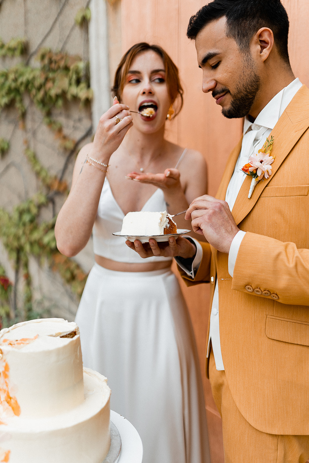 Couple de mariés qui mangent leur Wedding cake doré aux fruits exotiques au Château de Sienne en Provence dans le Gard – mariage moderne et coloré