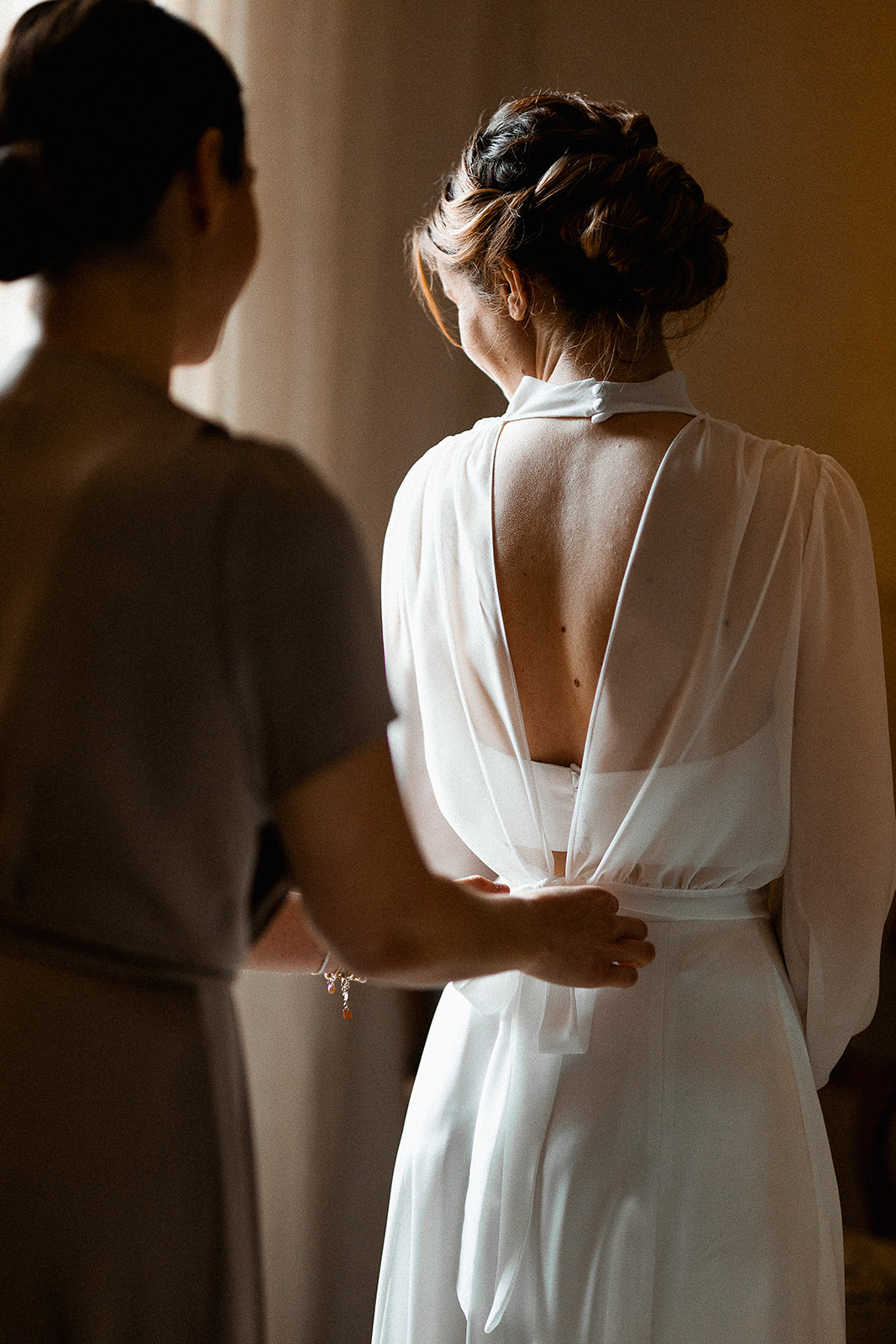 Détails d'un dos de robe de mariée moderne photographiée pendant les préparatifs de mariage au Château de Sienne en Provenceré